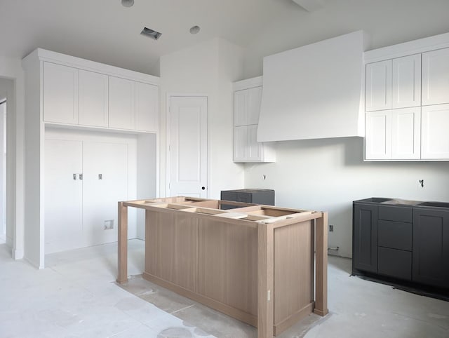 kitchen featuring white cabinetry and vaulted ceiling