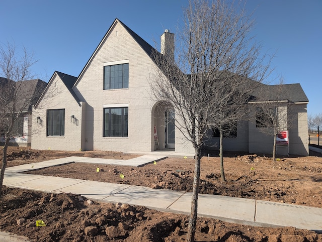 view of front of property with brick siding and a chimney