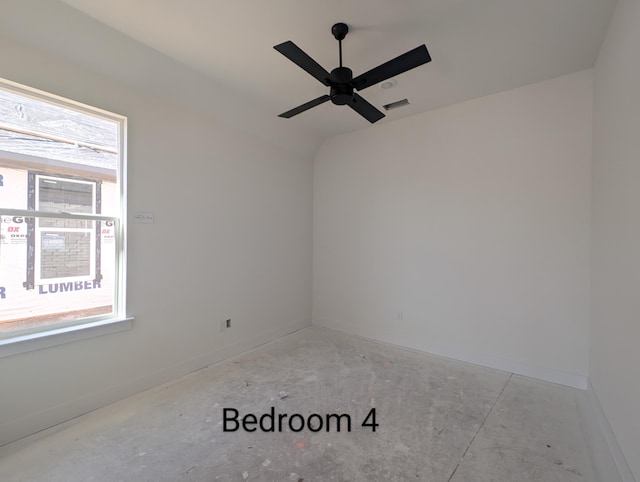 empty room with lofted ceiling, a ceiling fan, visible vents, and a wealth of natural light