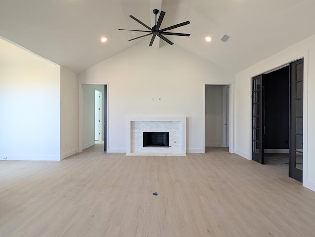 unfurnished living room with visible vents, a fireplace with flush hearth, light wood-style flooring, baseboards, and ceiling fan