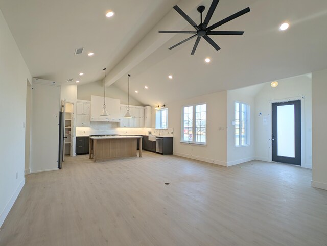 kitchen with high vaulted ceiling, white cabinets, and beam ceiling