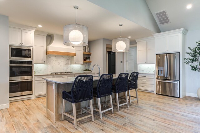 kitchen featuring tasteful backsplash, visible vents, appliances with stainless steel finishes, premium range hood, and recessed lighting