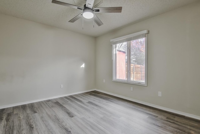 empty room featuring ceiling fan, hardwood / wood-style flooring, and a textured ceiling