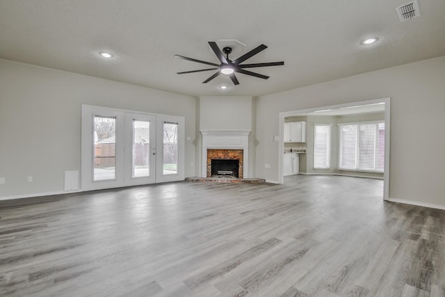 unfurnished living room featuring ceiling fan and light hardwood / wood-style floors