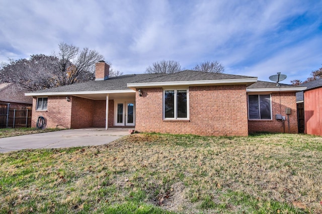 rear view of house featuring french doors, a patio area, and a lawn