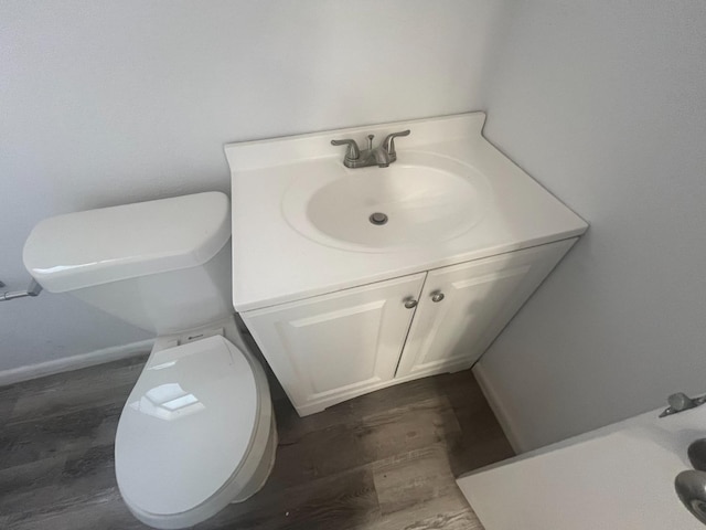 bathroom with vanity, toilet, and wood-type flooring