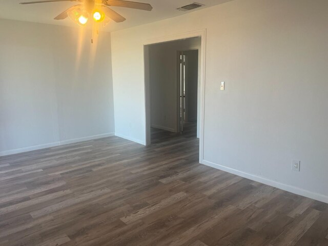 empty room with ceiling fan and dark hardwood / wood-style flooring