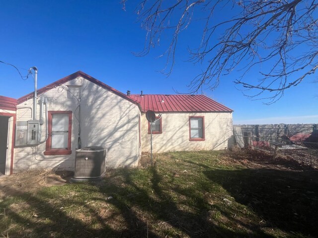 view of property exterior with a yard and central air condition unit