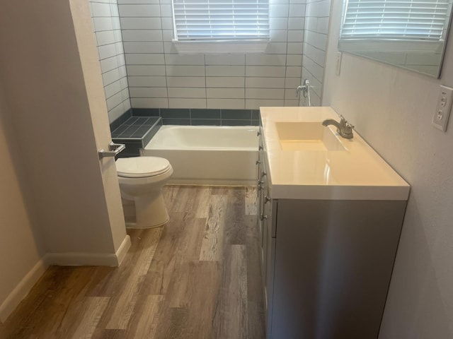 bathroom with vanity, hardwood / wood-style floors, a tub, and toilet