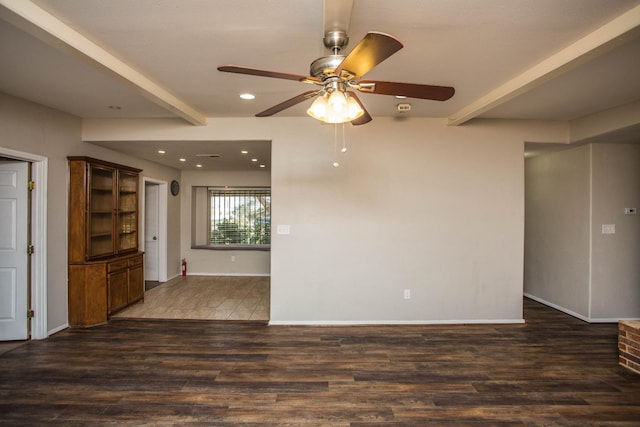 unfurnished living room featuring beam ceiling, dark wood-type flooring, and ceiling fan