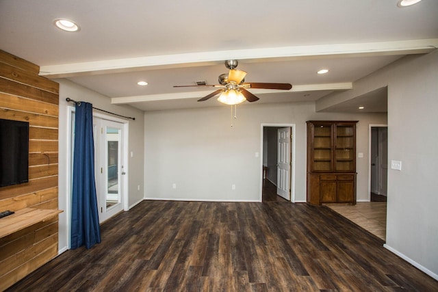 unfurnished living room with beamed ceiling, ceiling fan, and dark hardwood / wood-style flooring