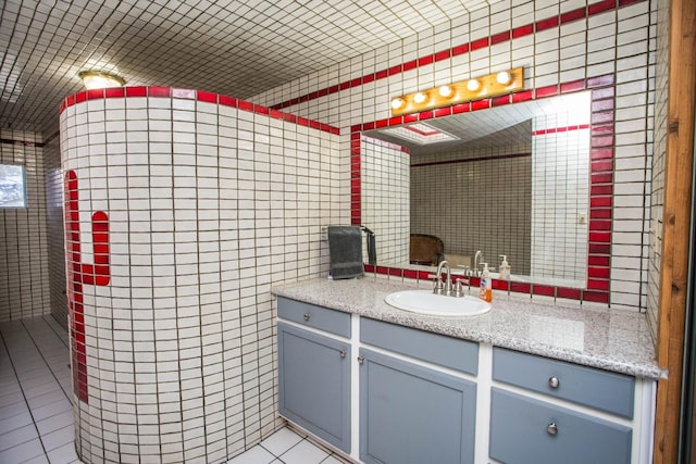 bathroom with vanity, tile patterned flooring, and tile walls