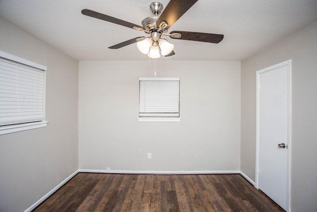 empty room featuring dark hardwood / wood-style flooring, ceiling fan, and a textured ceiling