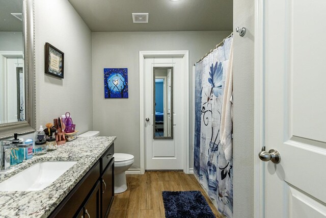 2541 137th St, Lubbock, TX 79423 - bathroom featuring vanity, hardwood / wood-style floors, curtained shower, and toilet