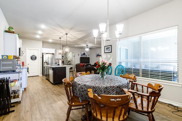 2541 137th St, Lubbock, TX 79423 - dining space with ceiling fan with notable chandelier and light hardwood / wood-style flooring