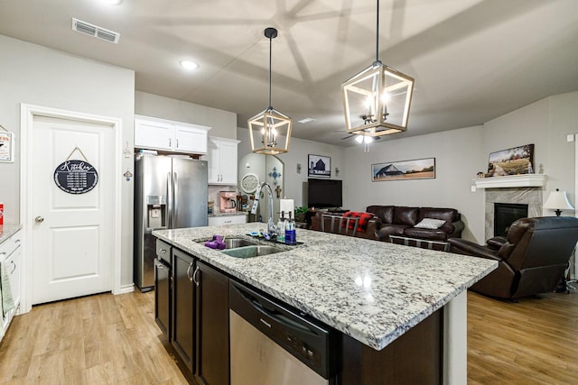 2541 137th St, Lubbock, TX 79423 - kitchen featuring sink, decorative light fixtures, a center island with sink, appliances with stainless steel finishes, and white cabinets