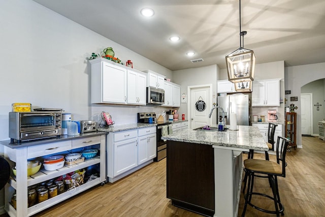 2541 137th St, Lubbock, TX 79423 - kitchen featuring white cabinetry, appliances with stainless steel finishes, a kitchen island with sink, and sink