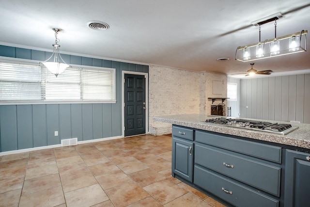 kitchen with pendant lighting, light tile patterned floors, a wealth of natural light, and stainless steel gas stovetop