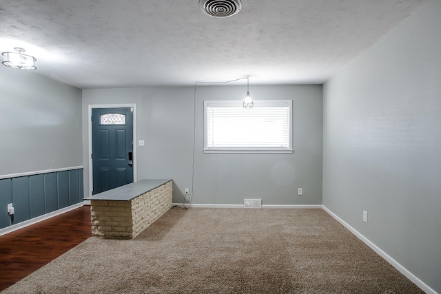 carpeted entryway featuring a textured ceiling