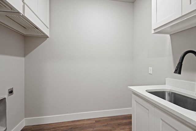 laundry room with cabinet space, baseboards, dark wood finished floors, hookup for an electric dryer, and a sink