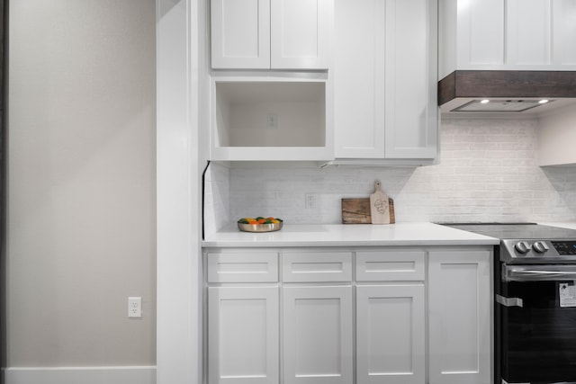 kitchen featuring light countertops, electric stove, and white cabinetry