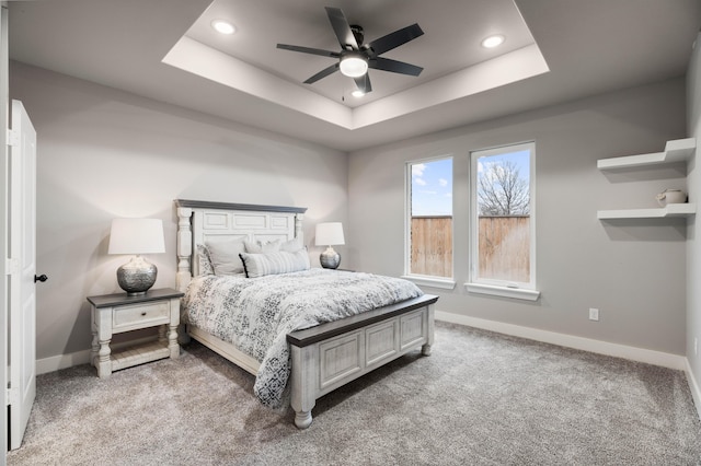 bedroom featuring carpet floors, a raised ceiling, and baseboards