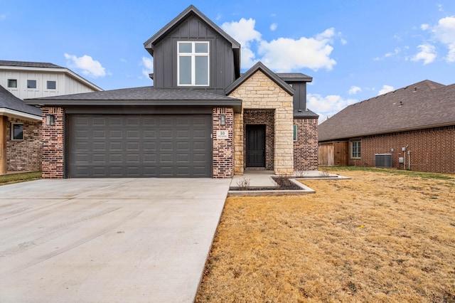 view of front of home with board and batten siding, concrete driveway, brick siding, and stone siding