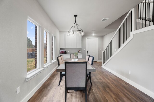 dining space featuring a chandelier, visible vents, baseboards, and dark wood-style floors