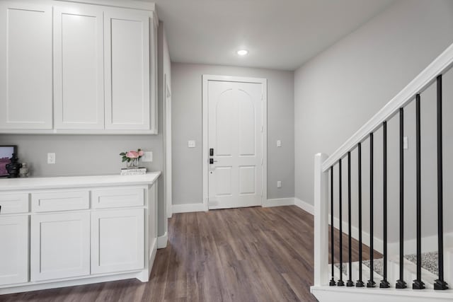 entryway featuring dark wood-type flooring, recessed lighting, baseboards, and stairs