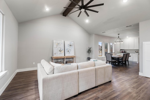 living room featuring vaulted ceiling with beams, ceiling fan with notable chandelier, visible vents, baseboards, and dark wood-style floors