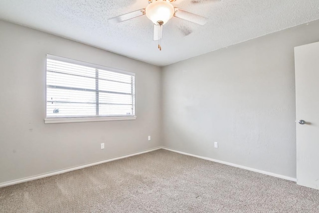 carpeted empty room with ceiling fan and a textured ceiling