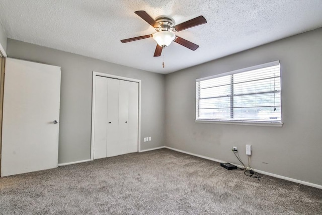 unfurnished bedroom with ceiling fan, light carpet, a closet, and a textured ceiling