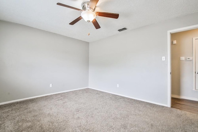 empty room featuring ceiling fan, carpet floors, and a textured ceiling