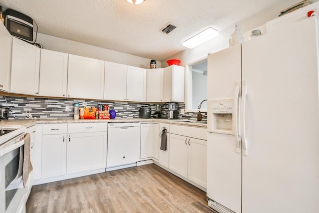 kitchen with white cabinetry, sink, and white appliances