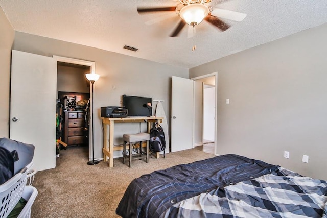 bedroom featuring light carpet, ceiling fan, and a textured ceiling