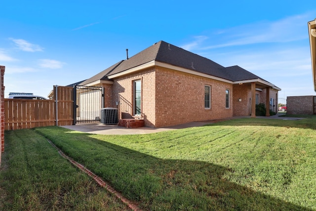 rear view of house featuring central AC, a patio area, and a lawn