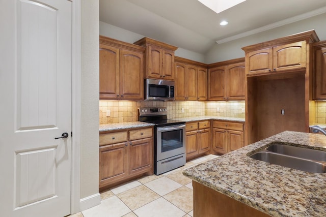 kitchen featuring tasteful backsplash, sink, stainless steel appliances, and light stone countertops