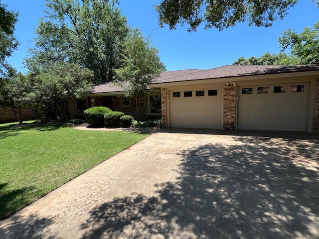 ranch-style home with a garage and a front lawn