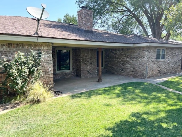 rear view of house featuring a yard and a patio