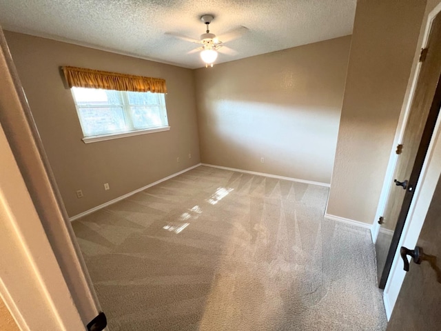 carpeted spare room with a textured ceiling and ceiling fan