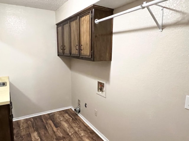 washroom with dark wood-type flooring, hookup for a washing machine, cabinets, hookup for a gas dryer, and hookup for an electric dryer