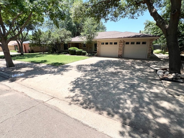 ranch-style home with a garage and a front lawn