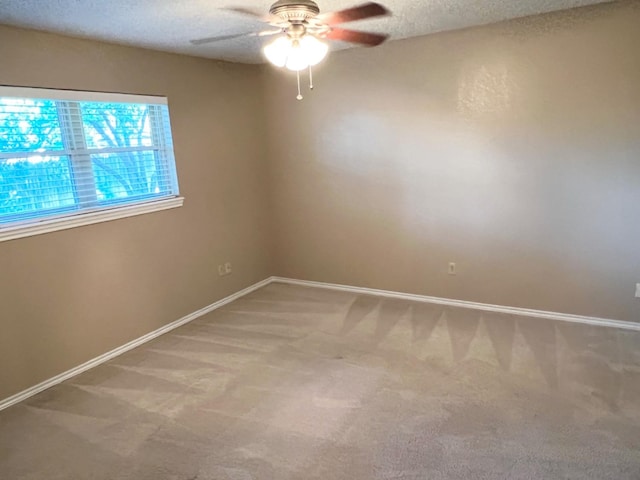 carpeted empty room with ceiling fan and a textured ceiling