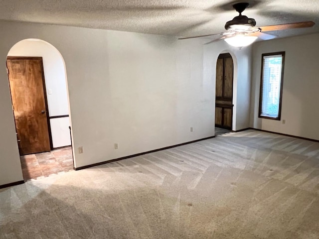 unfurnished room with ceiling fan, light carpet, and a textured ceiling