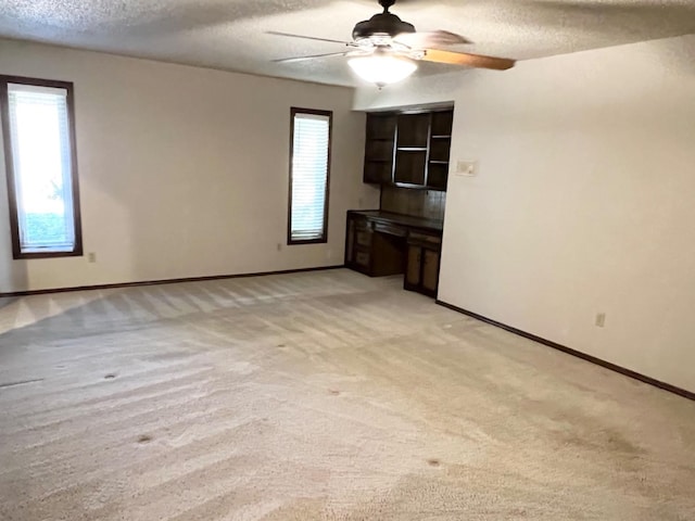 carpeted spare room with ceiling fan and a textured ceiling