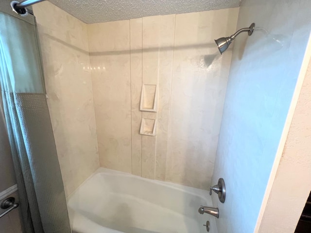 bathroom featuring shower / bath combination with curtain and a textured ceiling