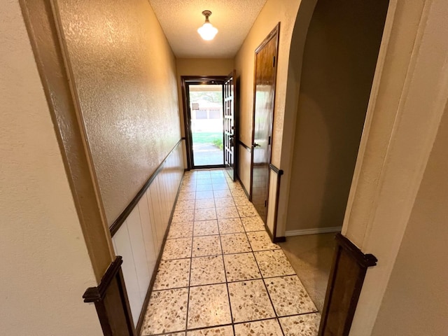 doorway to outside featuring light tile patterned floors and a textured ceiling