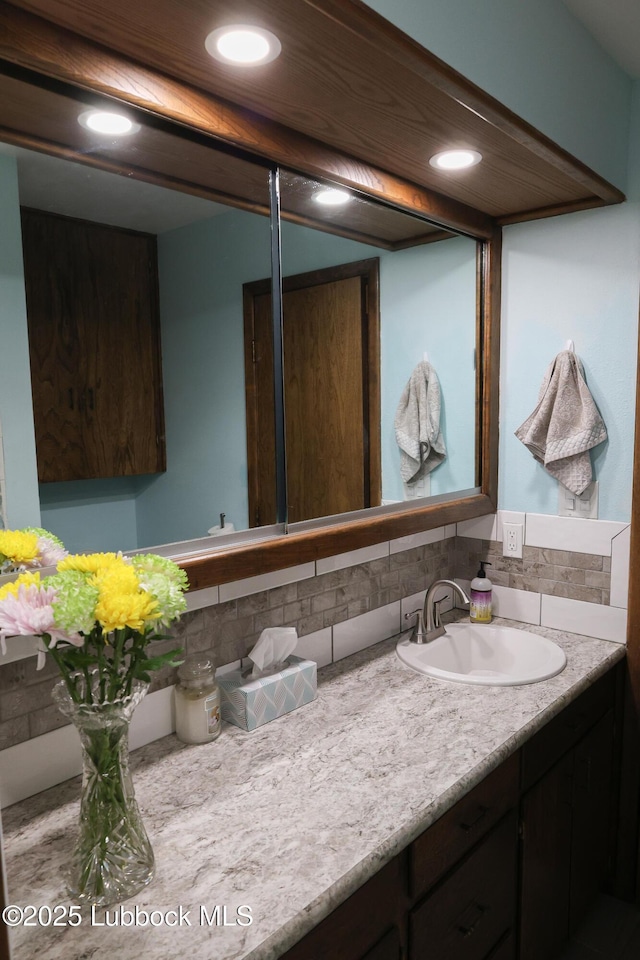 2512 Holliday Dr, Plainview, TX 79072 - bathroom with decorative backsplash, vanity, and recessed lighting