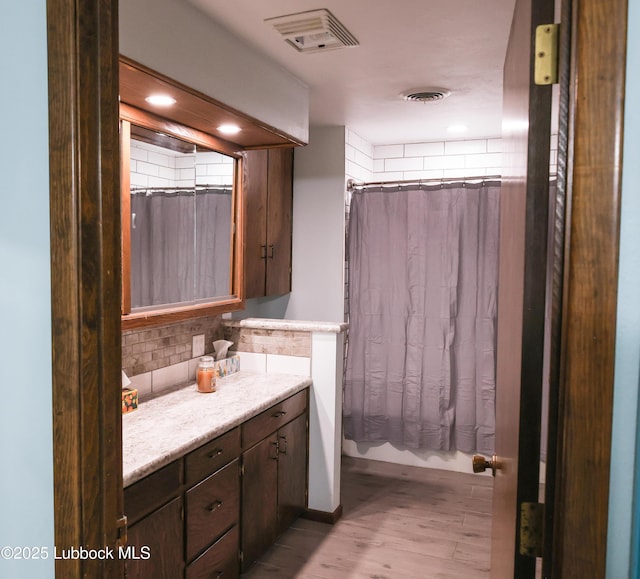 2512 Holliday Dr, Plainview, TX 79072 - full bathroom with vanity, tasteful backsplash, wood finished floors, and recessed lighting