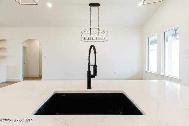 7450 55th St, Lubbock, TX 79407 - kitchen featuring a sink, light stone countertops, arched walkways, hanging light fixtures, and recessed lighting